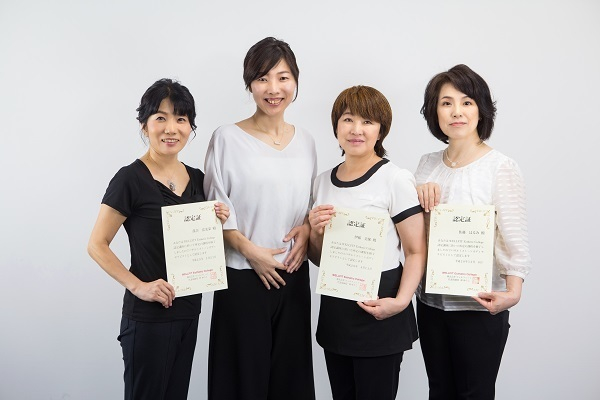 受講後のアフターフォローや定期練習会も充実したバザルト®ストーンスクールで、ホワイトボードの前に立ちテキストを持って講義を行う女性講師と受講生たちの様子